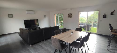 a living room with a wooden table and chairs at Villa vacances in Les Cluses