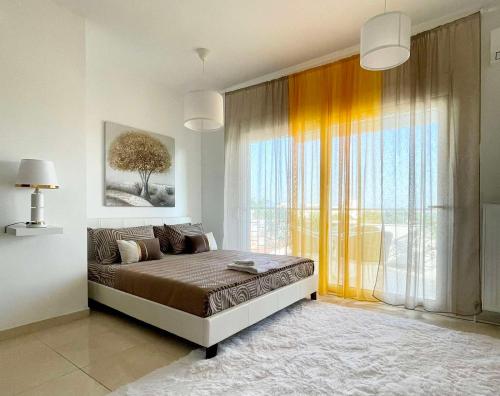 Un dormitorio con una cama y una ventana grande. en Luxury Living SKG 1, en Tesalónica