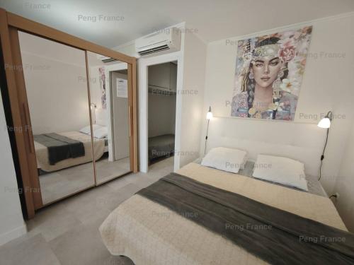 une chambre avec un lit et un tableau au mur dans l'établissement Appartement Village Naturiste Savannah, au Cap d'Agde