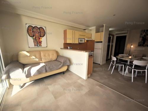 un salon avec un canapé et une cuisine avec une table dans l'établissement Appartement Village Naturiste Savannah, au Cap d'Agde