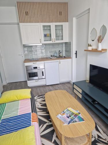 un salon avec une table et une cuisine dans l'établissement Appartement Bella, à Saint-Denis