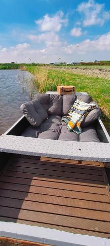 a couch sitting on a boat in the water at Wellness Bed & Breakfast Pergamo in Voorhout