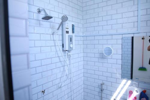 a white tiled shower with a shower head in a bathroom at Green Dream Homestay 3 Kota Bharu 3 Aircond Room With Wifi & Netflix in Kota Bharu