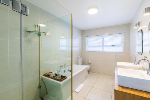 a bathroom with a tub and a sink and a shower at Dune Beach House in Wilderness