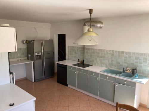 La cuisine est équipée d'un réfrigérateur et d'un évier. dans l'établissement Grande maison avec piscine, à Aix-en-Provence