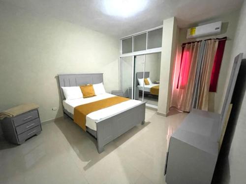 a bedroom with a large bed and a window at Balcon Skyline 2 in Jarabacoa