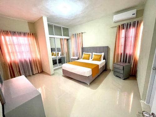 a bedroom with a bed with orange and yellow pillows at Balcon Skyline 2 in Jarabacoa