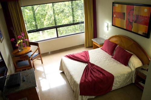 a bedroom with a large bed and a large window at Hotel Emperador in Valencia
