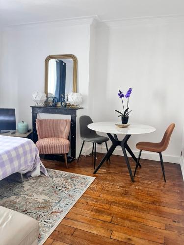Cette chambre comprend une table, des chaises et un miroir. dans l'établissement Rêve d'été à Paris, à Paris
