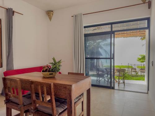 a living room with a table and a red couch at The Coco Paradise in Jambiani