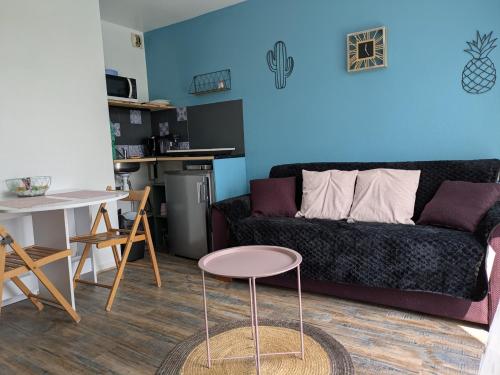 un salon avec un canapé et une table dans l'établissement studio Cosy proche hyper centre, à Quimper