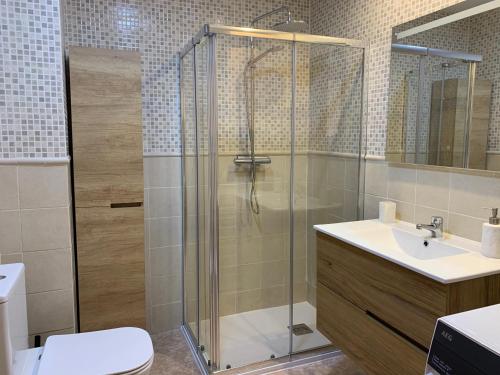 a bathroom with a shower and a toilet and a sink at Apartamento en Moraira Centro con Piscina in Moraira