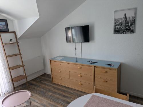 sypialnia z komodą z telewizorem na ścianie w obiekcie studio Cosy proche hyper centre w mieście Quimper