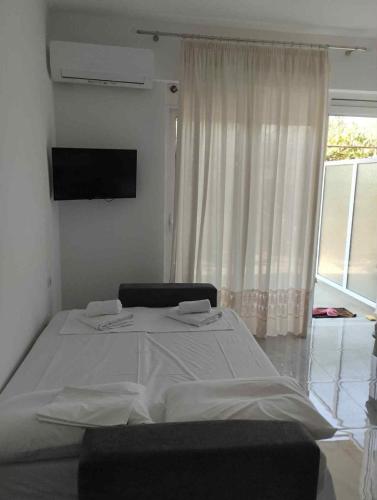 Un dormitorio con una gran cama blanca y una ventana. en Michelangelo, en Qeparo