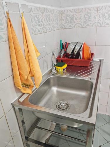 a kitchen sink with utensils and towels at MixxHome Seremban 2, Two Single Beds, Share Bathroom in Seremban