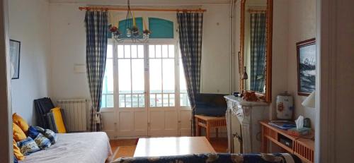 une chambre avec un lit et une grande fenêtre dans l'établissement le Tourbillon, à Mers-les-Bains