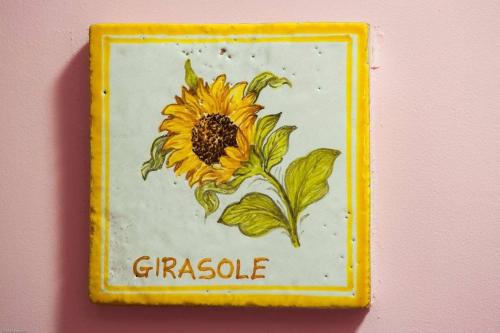 a sign with a sunflower painted on a wall at Casa Vacanze Salus in Cascia