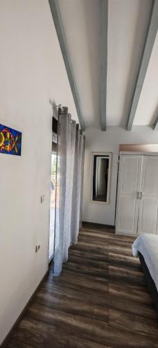 a room with a bed and a window with curtains at Merlo House Dol Hvar in Stari Grad