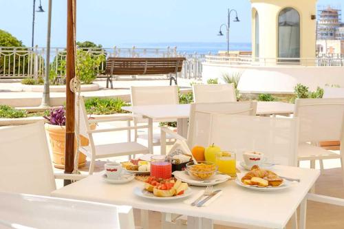 een tafel met borden eten erop met uitzicht op het strand bij Grand Hotel Mediterraneo in Santa Cesarea Terme