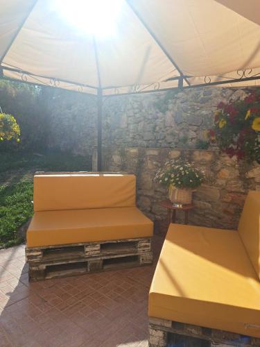 two benches sitting under a tent in a patio at B&B Il Rifugio della Felicità Civitella in Setri