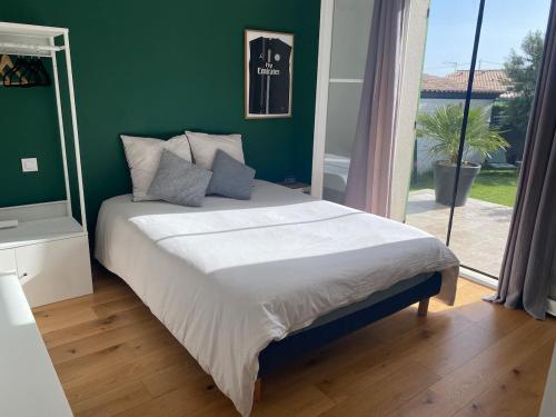 une chambre avec un grand lit avec un mur végétal dans l'établissement Home, à Pélissanne