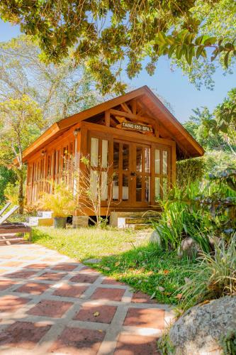 a small wooden house with a pathway in front of it at Hotel Gran Jimenoa in Jarabacoa