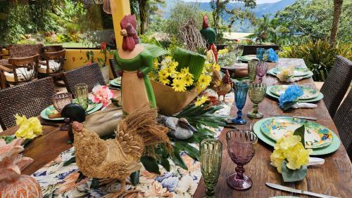 a wooden table with chicken decorations on top of it at San Felipe Lodge. Birding and Wellness in Cali