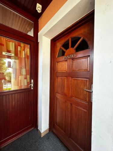 an entrance to a building with a wooden door at Polgármester Étterem és Panzió in Fertőszéplak