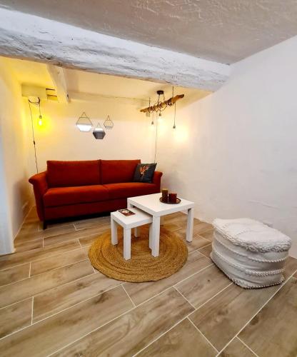 un salon avec un canapé rouge et une table dans l'établissement Charming studio Haut-de-Cagnes, à Cagnes-sur-Mer