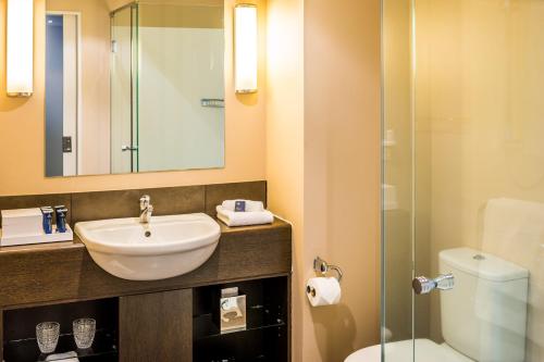 a bathroom with a sink and a toilet and a shower at Bolton Hotel in Wellington