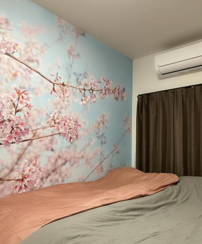 a bedroom with a painting ofakura trees on the wall at 桜屋Sakuraya101 in Tokyo