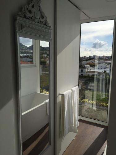 a bathroom with a bath tub and a window at Casa Senhora da Rosa in Ponta Delgada