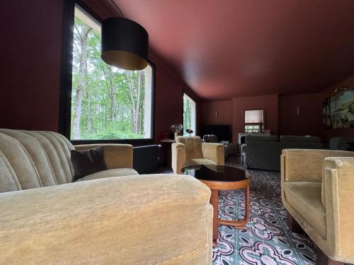 - un salon avec un lit, des chaises et une fenêtre dans l'établissement Domaine des Quatre Vents, à Nançay