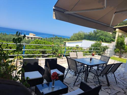 a patio with a table and chairs and an umbrella at Olive tree villa in Ligia