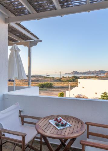 a table and chairs on a balcony with a view of the desert at Agnanti View Hotel in Pachaina