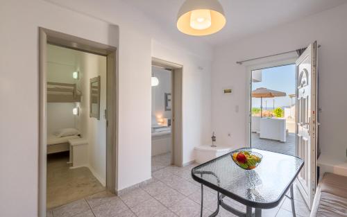 a dining room with a table and a view of a bathroom at Agnanti View Hotel in Pachaina