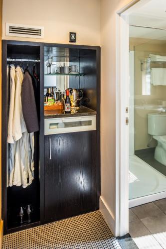 a kitchen with a black closet with a sink at Bolton Hotel in Wellington