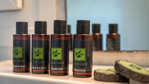 a group of four bottles of hair care products on a counter at Agnanti View Hotel in Pachaina