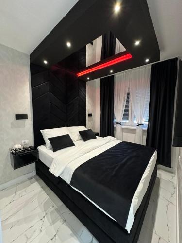 a bedroom with a large bed with a black headboard at Apartment Aristos in Modriča
