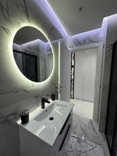 Un baño blanco con lavabo y espejo. en Apartment Aristos, en Modriča