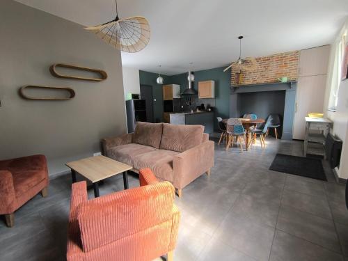 un salon avec un canapé, des chaises et une table dans l'établissement Maison proche Baie de Somme mer campagne, à Tully