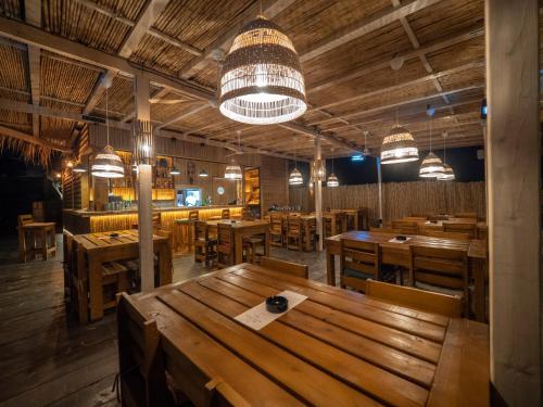 a restaurant with wooden tables and chairs and lights at Trsteno Beach Apartments in Budva
