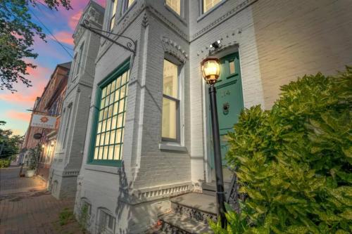 a white house with a green door and a street light at The Verdigris| 1800s Charm| King St| Easy Parking in Alexandria