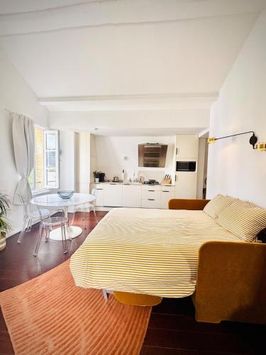 a room with a bed and a table and a kitchen at La Cour Dudon - Amazing & central appartment in Bordeaux in Bordeaux