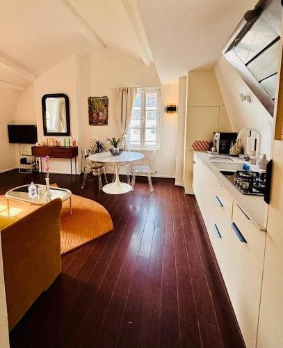 - une cuisine et un salon avec une table et un comptoir dans l'établissement La Cour Dudon - Amazing & central appartment in Bordeaux, à Bordeaux