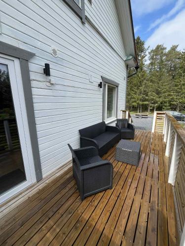 a patio with a couch and chairs on a wooden deck at Villa Kuninkaankivi in Kalajoki