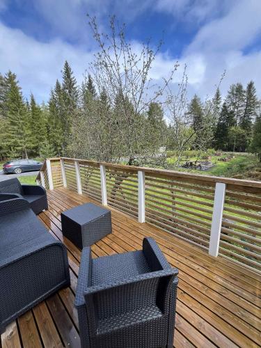 a wooden deck with four chairs and a fence at Villa Kuninkaankivi in Kalajoki