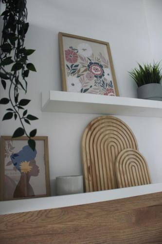 a shelf with two pictures and a wooden chair at Quartier 70 Bremerhaven in Bremerhaven