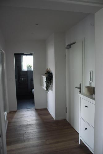 a room with a hallway with white walls and wood floors at Quartier 70 Bremerhaven in Bremerhaven