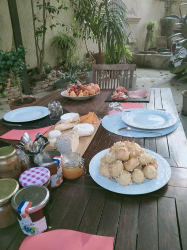 une table en bois avec des assiettes de nourriture dessus dans l'établissement l'aedes, à Orange